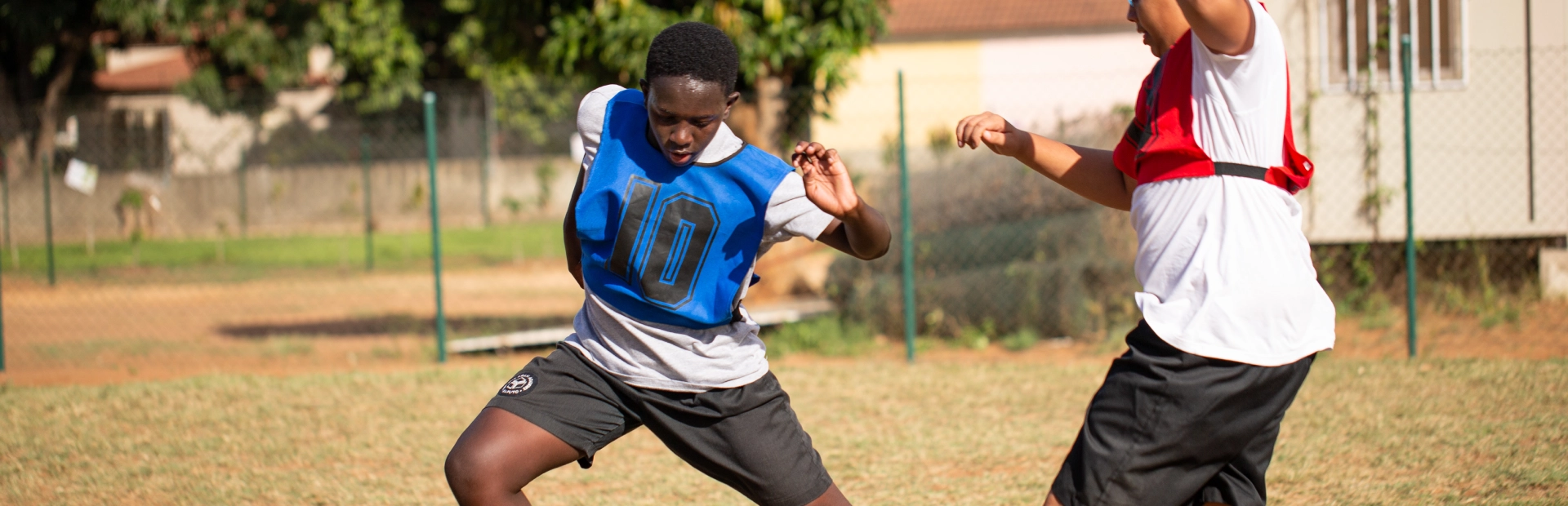 : Students playing football on the school field.
